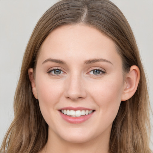 Joyful white young-adult female with long  brown hair and grey eyes