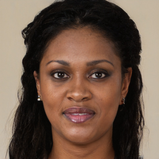 Joyful black young-adult female with long  brown hair and brown eyes