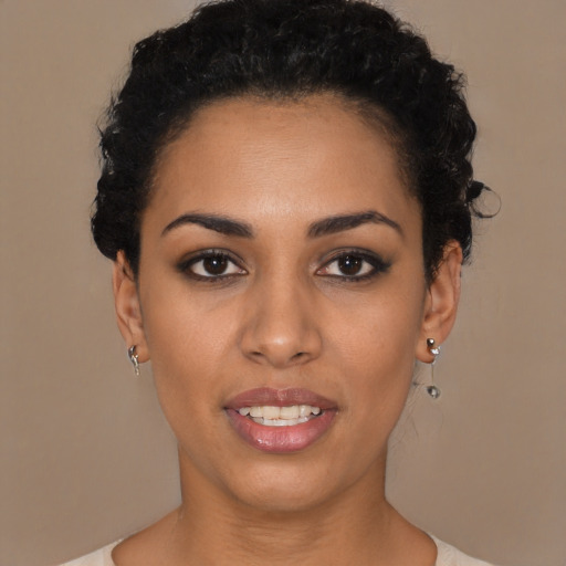 Joyful black young-adult female with short  black hair and brown eyes