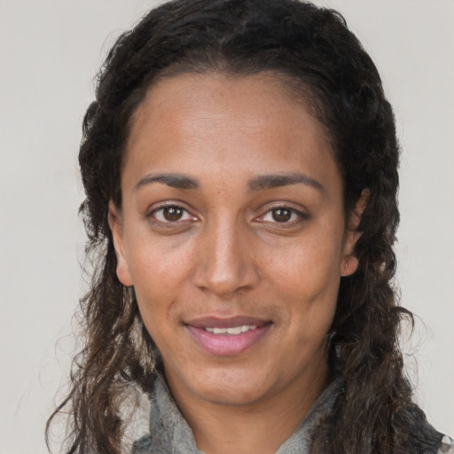 Joyful black adult female with long  brown hair and brown eyes