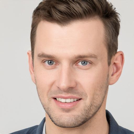 Joyful white young-adult male with short  brown hair and grey eyes