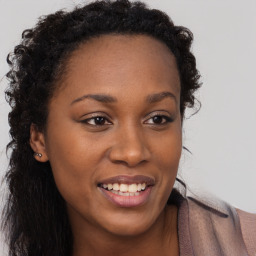 Joyful black young-adult female with long  brown hair and brown eyes