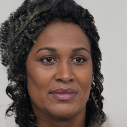 Joyful black adult female with long  brown hair and brown eyes