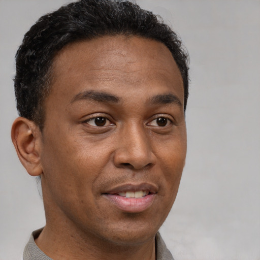 Joyful latino young-adult male with short  brown hair and brown eyes