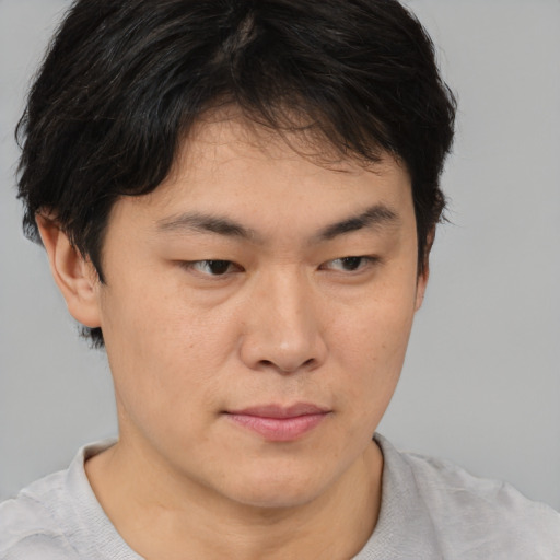 Joyful asian young-adult male with short  brown hair and brown eyes
