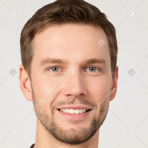 Joyful white young-adult male with short  brown hair and grey eyes