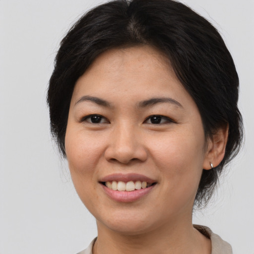 Joyful asian young-adult female with medium  brown hair and brown eyes