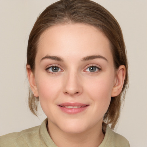 Joyful white young-adult female with medium  brown hair and grey eyes