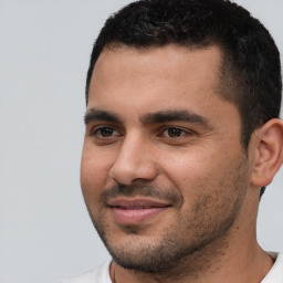 Joyful white young-adult male with short  black hair and brown eyes