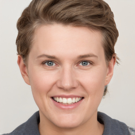 Joyful white young-adult female with short  brown hair and grey eyes