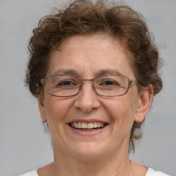 Joyful white middle-aged female with medium  brown hair and blue eyes