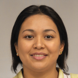 Joyful latino young-adult female with medium  brown hair and brown eyes