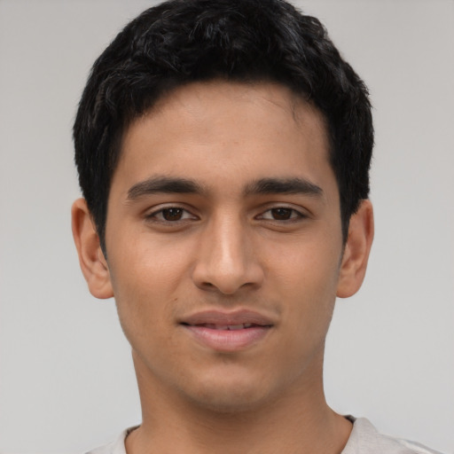 Joyful latino young-adult male with short  black hair and brown eyes