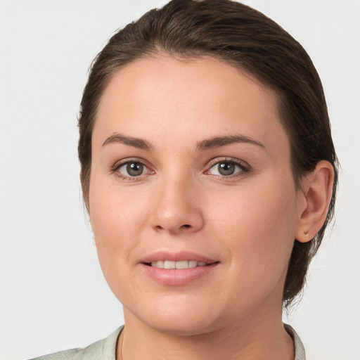 Joyful white young-adult female with medium  brown hair and grey eyes