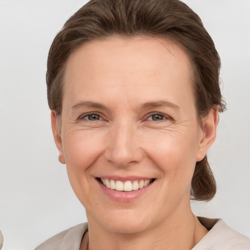 Joyful white adult female with short  brown hair and grey eyes