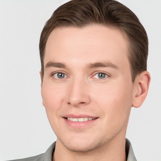 Joyful white young-adult male with short  brown hair and grey eyes