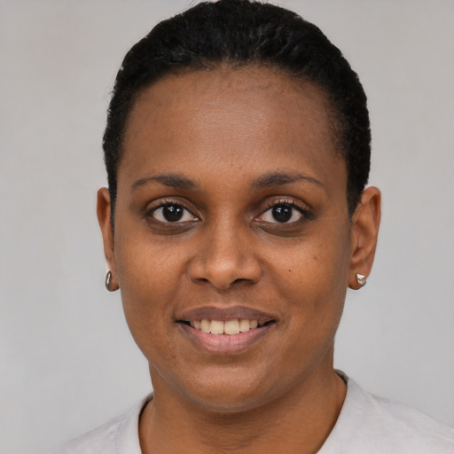Joyful black young-adult female with short  black hair and brown eyes