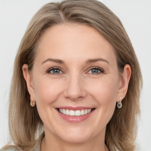 Joyful white adult female with long  brown hair and grey eyes