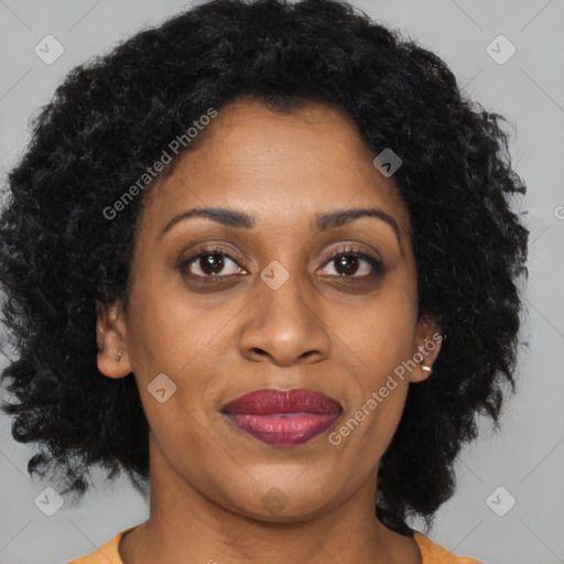 Joyful black adult female with long  brown hair and brown eyes