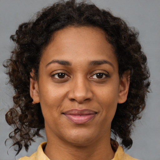 Joyful black adult female with medium  brown hair and brown eyes