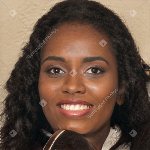 Joyful black young-adult female with long  black hair and brown eyes