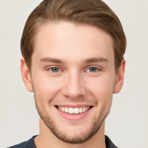 Joyful white young-adult male with short  brown hair and grey eyes