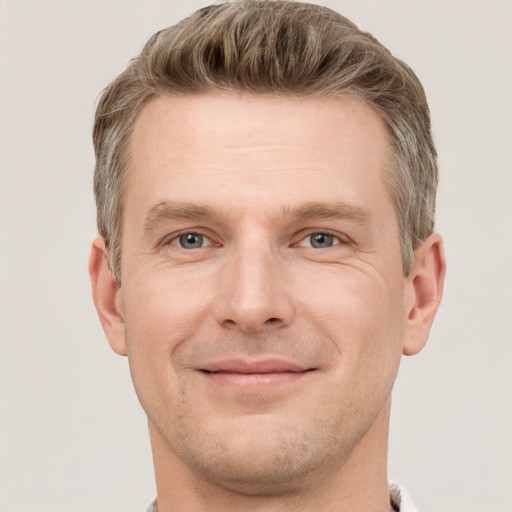 Joyful white adult male with short  brown hair and grey eyes