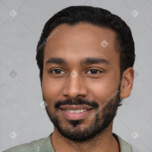 Joyful black young-adult male with short  black hair and brown eyes