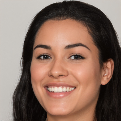 Joyful latino young-adult female with long  brown hair and brown eyes