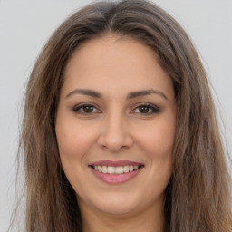 Joyful white young-adult female with long  brown hair and brown eyes