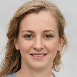 Joyful white young-adult female with medium  brown hair and blue eyes