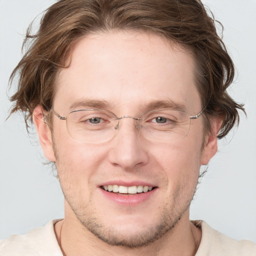 Joyful white adult male with short  brown hair and blue eyes