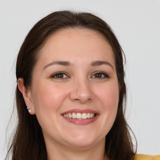 Joyful white young-adult female with long  brown hair and brown eyes