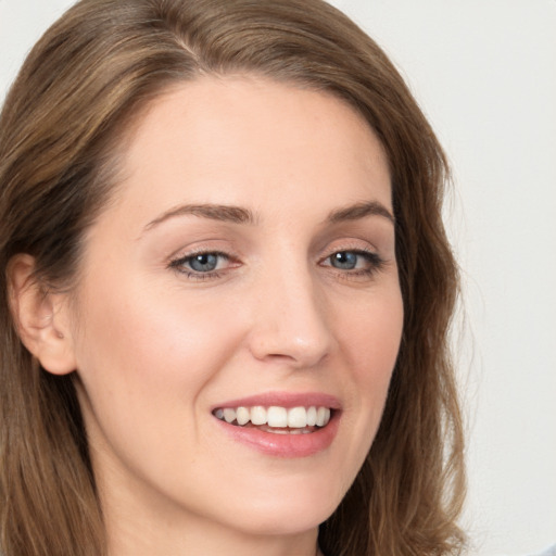 Joyful white young-adult female with long  brown hair and grey eyes