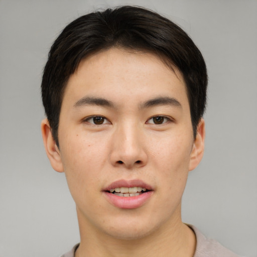 Joyful asian young-adult male with short  brown hair and brown eyes