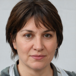 Joyful white adult female with medium  brown hair and grey eyes