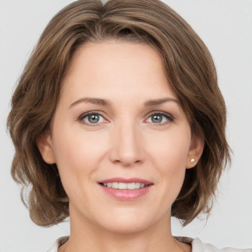 Joyful white young-adult female with medium  brown hair and green eyes