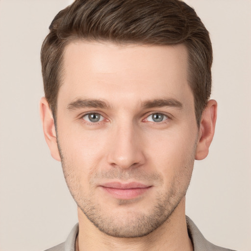 Joyful white young-adult male with short  brown hair and grey eyes