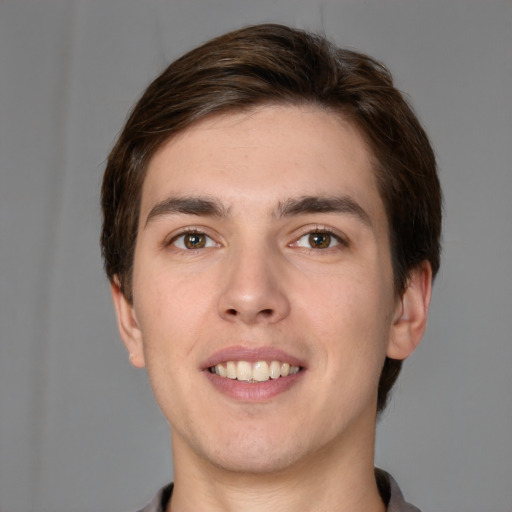 Joyful white young-adult male with short  brown hair and grey eyes