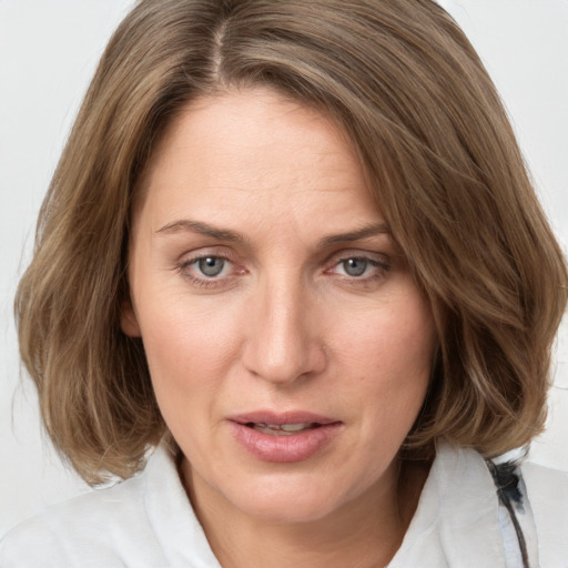 Joyful white adult female with medium  brown hair and grey eyes