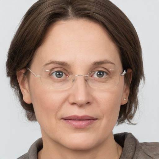 Joyful white adult female with medium  brown hair and grey eyes