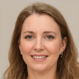 Joyful white adult female with long  brown hair and green eyes