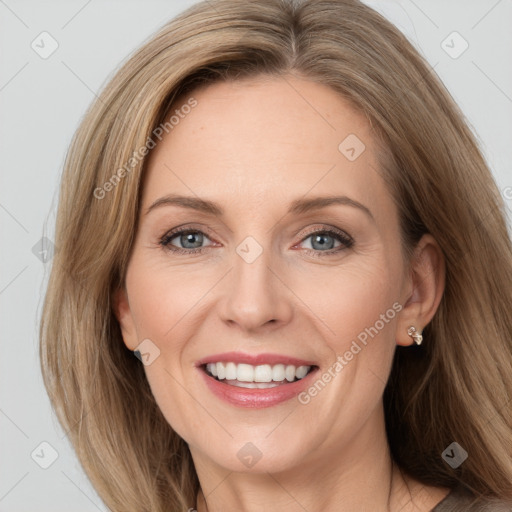 Joyful white adult female with long  brown hair and grey eyes