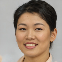 Joyful asian young-adult female with short  brown hair and brown eyes