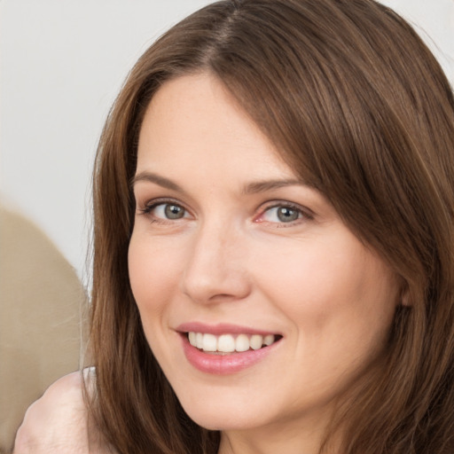 Joyful white young-adult female with long  brown hair and brown eyes