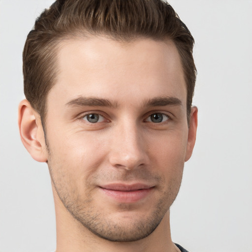 Joyful white young-adult male with short  brown hair and grey eyes