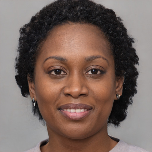 Joyful black adult female with medium  brown hair and brown eyes