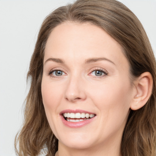 Joyful white young-adult female with long  brown hair and blue eyes