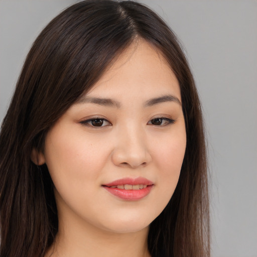 Joyful asian young-adult female with long  brown hair and brown eyes