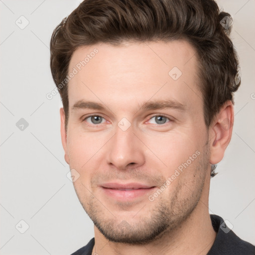 Joyful white young-adult male with short  brown hair and grey eyes